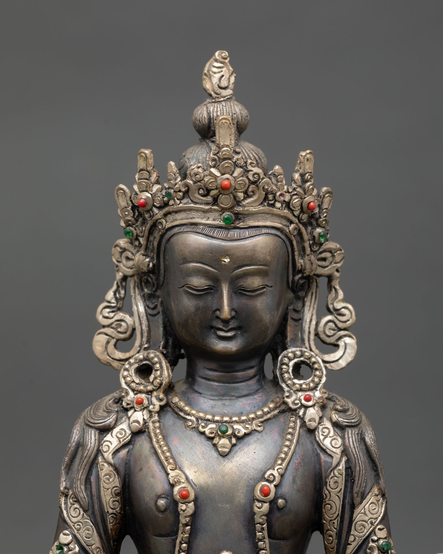 Close up Amitayus Buddha statue showing serene meditation expression and intricate Newari craftsmanship with detailed ornaments