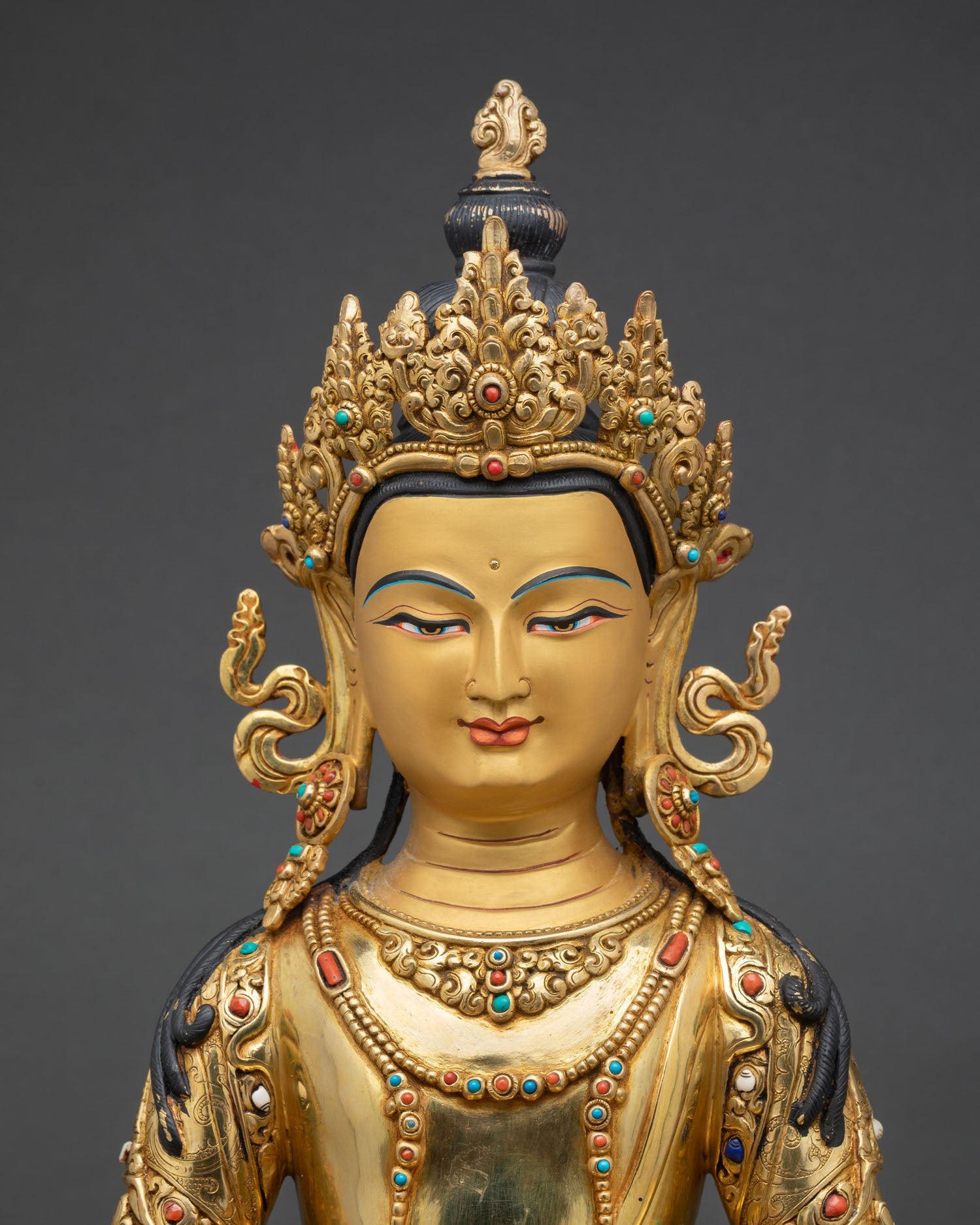 Close up Amitayus face detail gold painted finish semi precious stone inlay Himalayan Buddhist statue, spiritual craftsmanship Nepal
