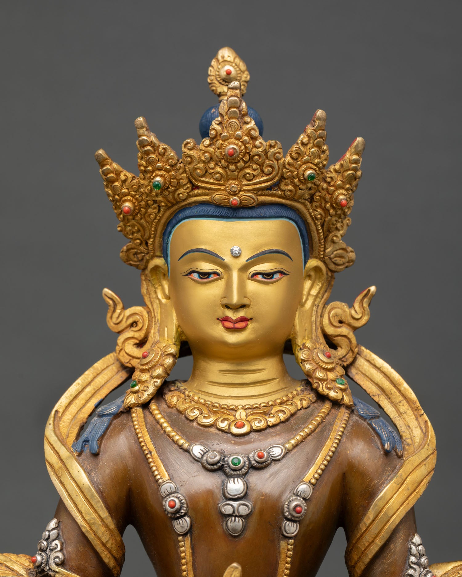 Close up Amitayus face gold painted serene expression five jeweled diadem semi precious stones detailed Himalayan artisan Buddhist statue