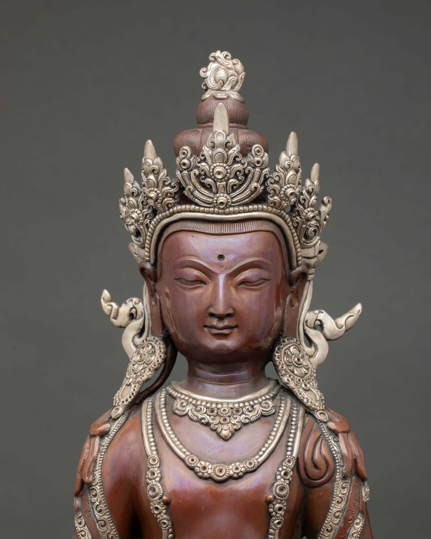 Close up Amitayus long life deity holding sacred vase on lotus pedestal with oxidized copper detail