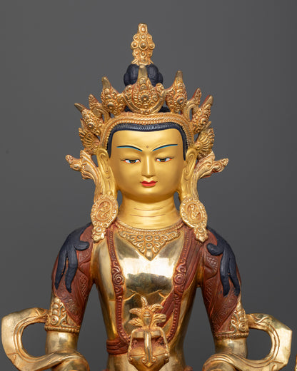 Close up Amitayus statue with 24K gold painted face and jewel crown.