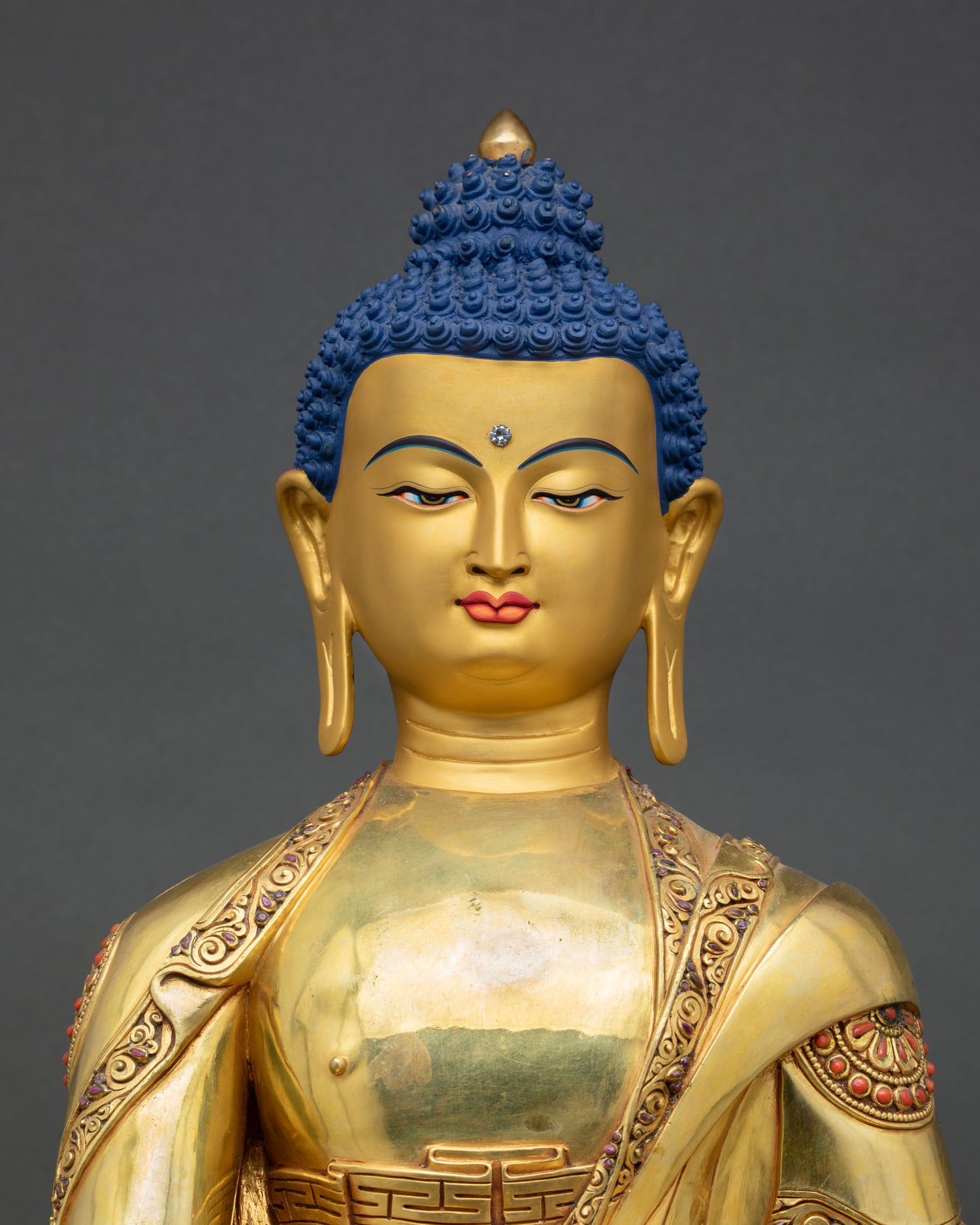 Close up Bhaisajyaguru Buddha face detail serene gold painted expression, Patan handcrafted Buddhist deity