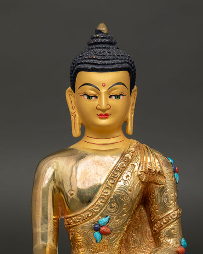 Close up Buddha Shakyamuni statue showing serene face with gold paint semi precious stone detailing