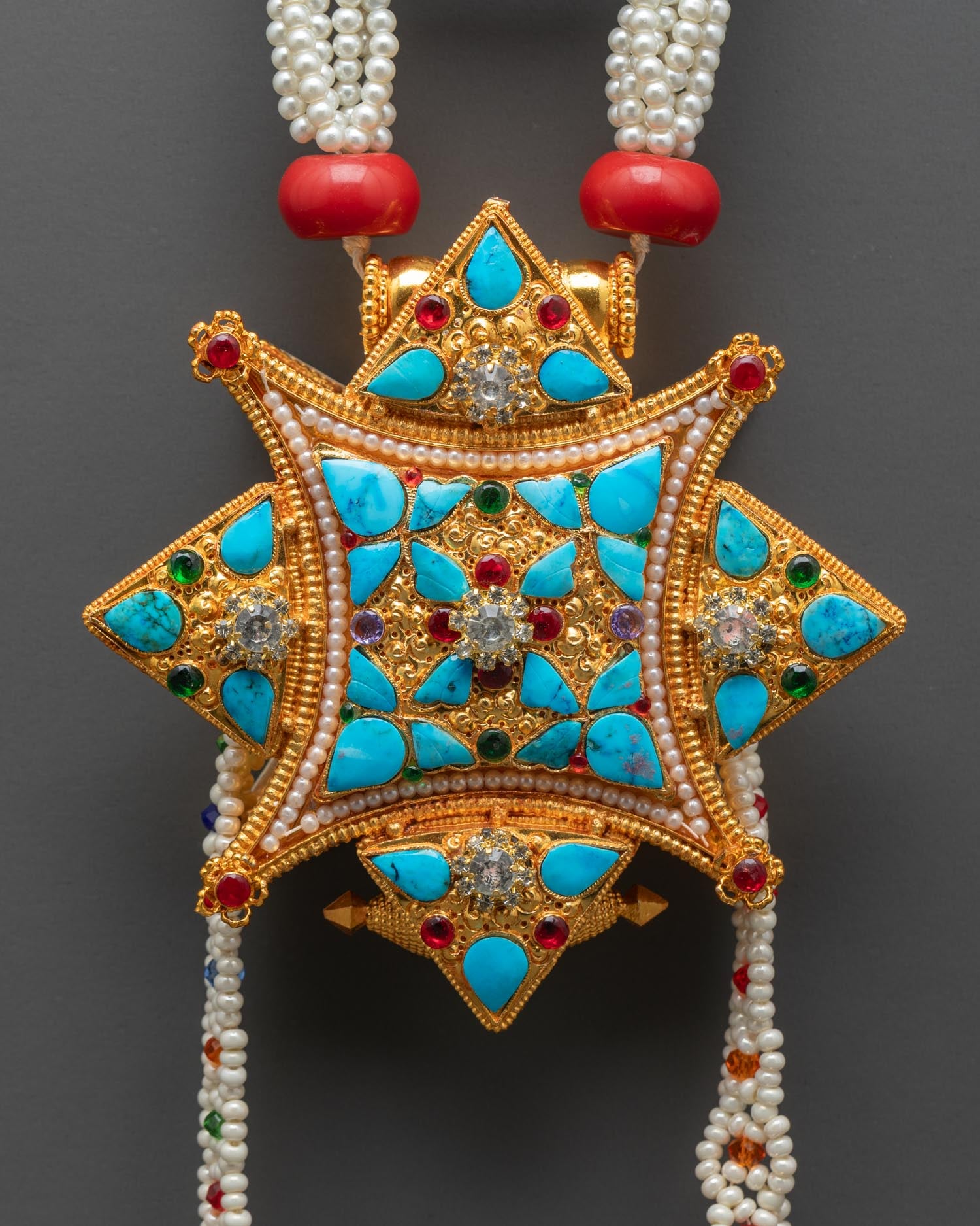 Close up detail of Ghau Mala locket pendant showing traditional Tibetan prayer box design gold plated finish and intricate sacred carvings