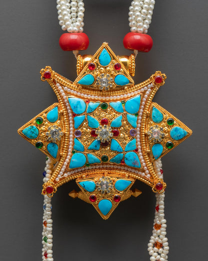 Close up detail of Ghau Mala locket pendant showing traditional Tibetan prayer box design gold plated finish and intricate sacred carvings