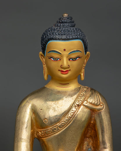Close up detail of Shakyamuni Buddha statue showing gold painted face and traditional Newari craftsmanship.