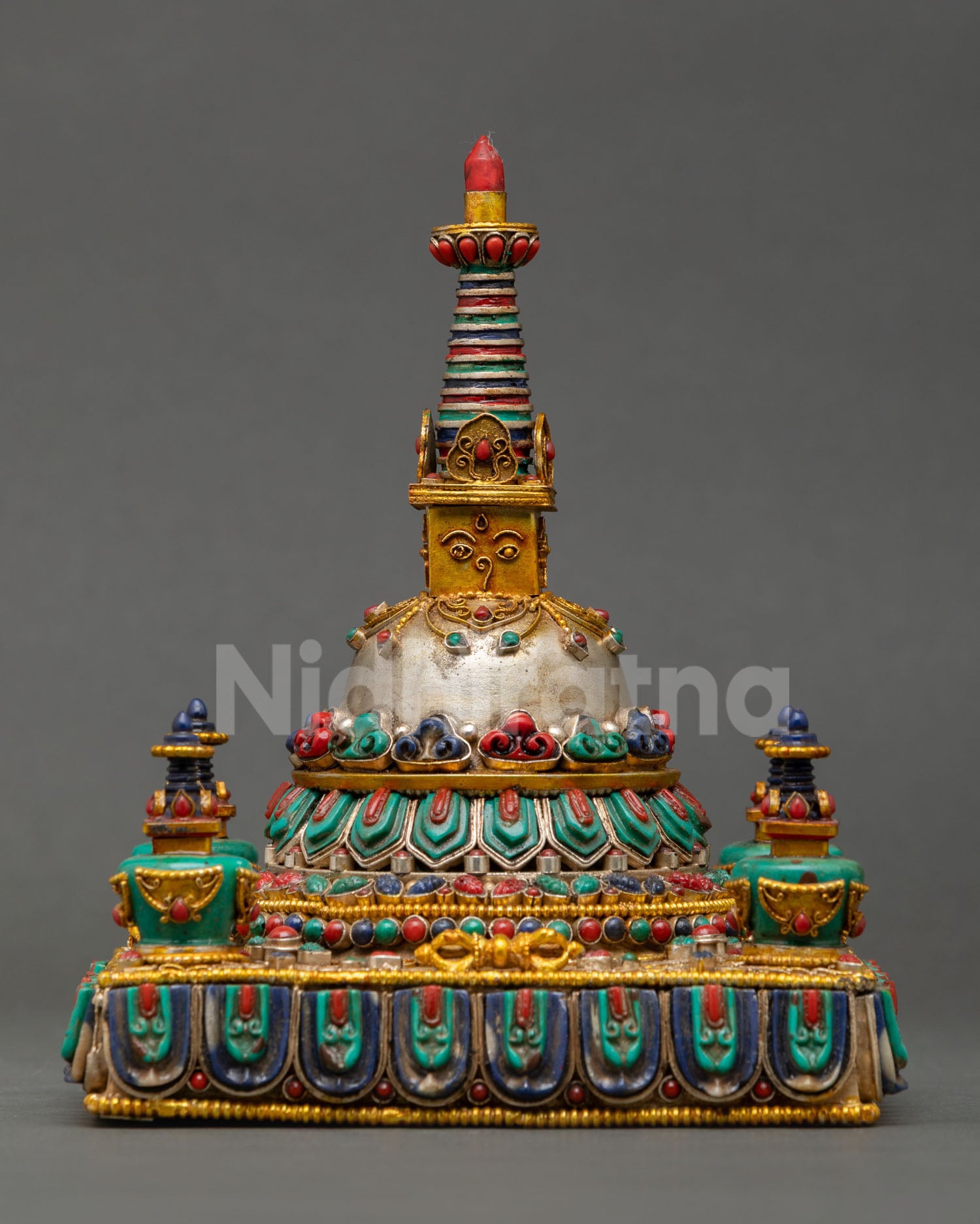 Close up detailed view of Tibetan Stupa showing turquoise coral lapis lazuli malachite inlays, gold gilded sacred Buddhist monument from Kathmandu Valley craftsmanship