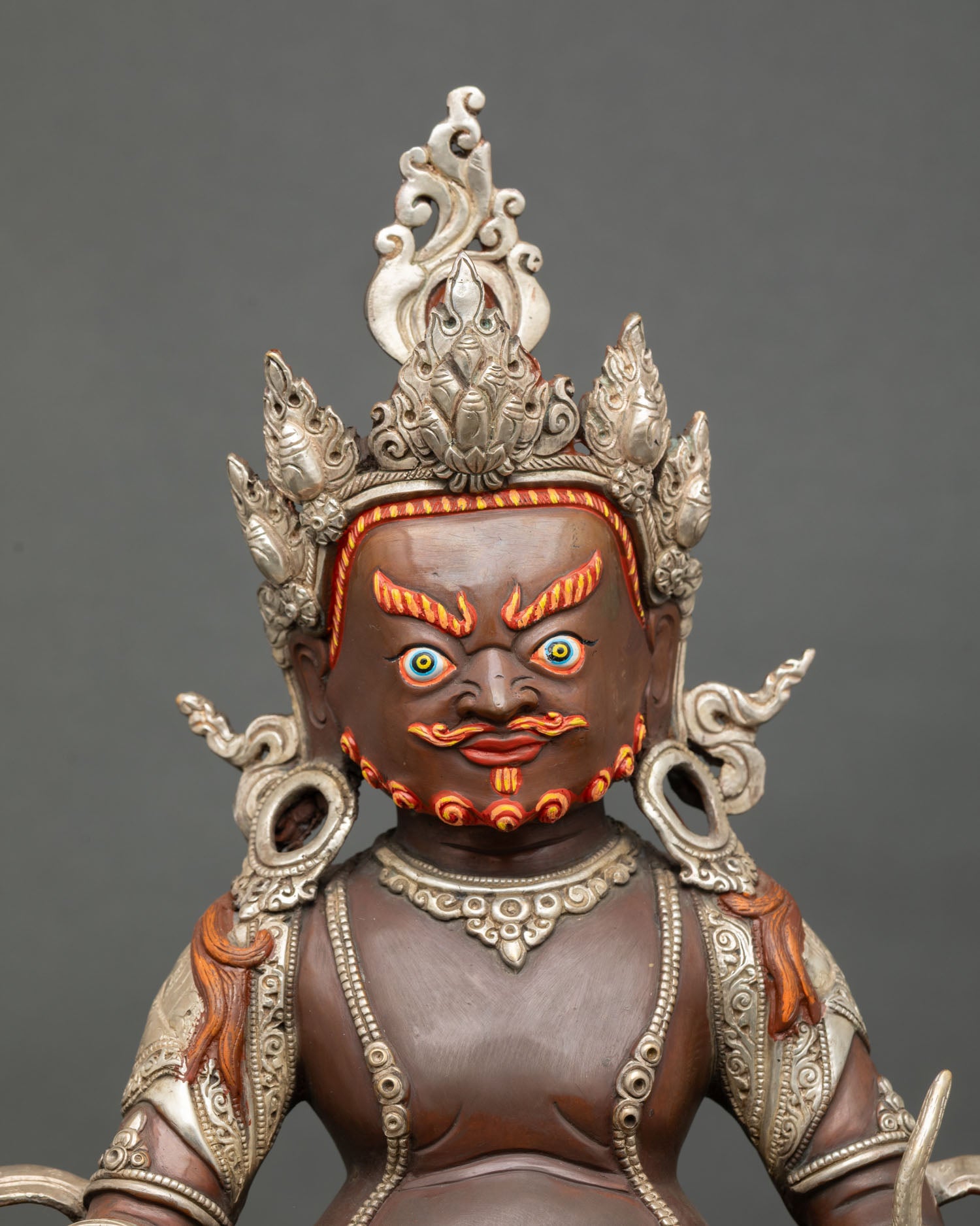 Close up Dzambhala face detail hand painted acrylic colors radiant expression Buddhist wealth god mongoose citron fruit sacred Himalayan art