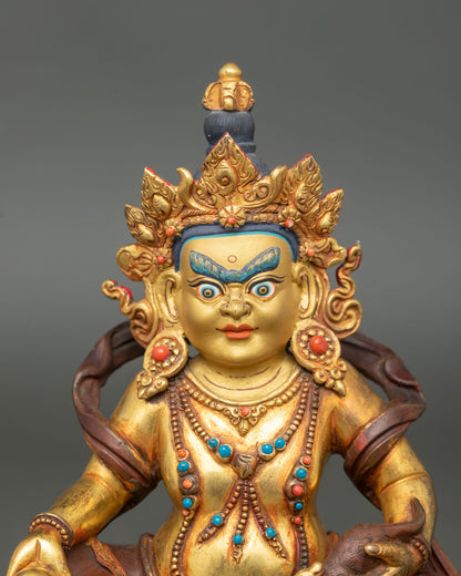 Close up Dzambhala face detail wrathful gold painted expression wealth deity Himalayan Buddhist art Newari craftsmanship sacred prosperity statue