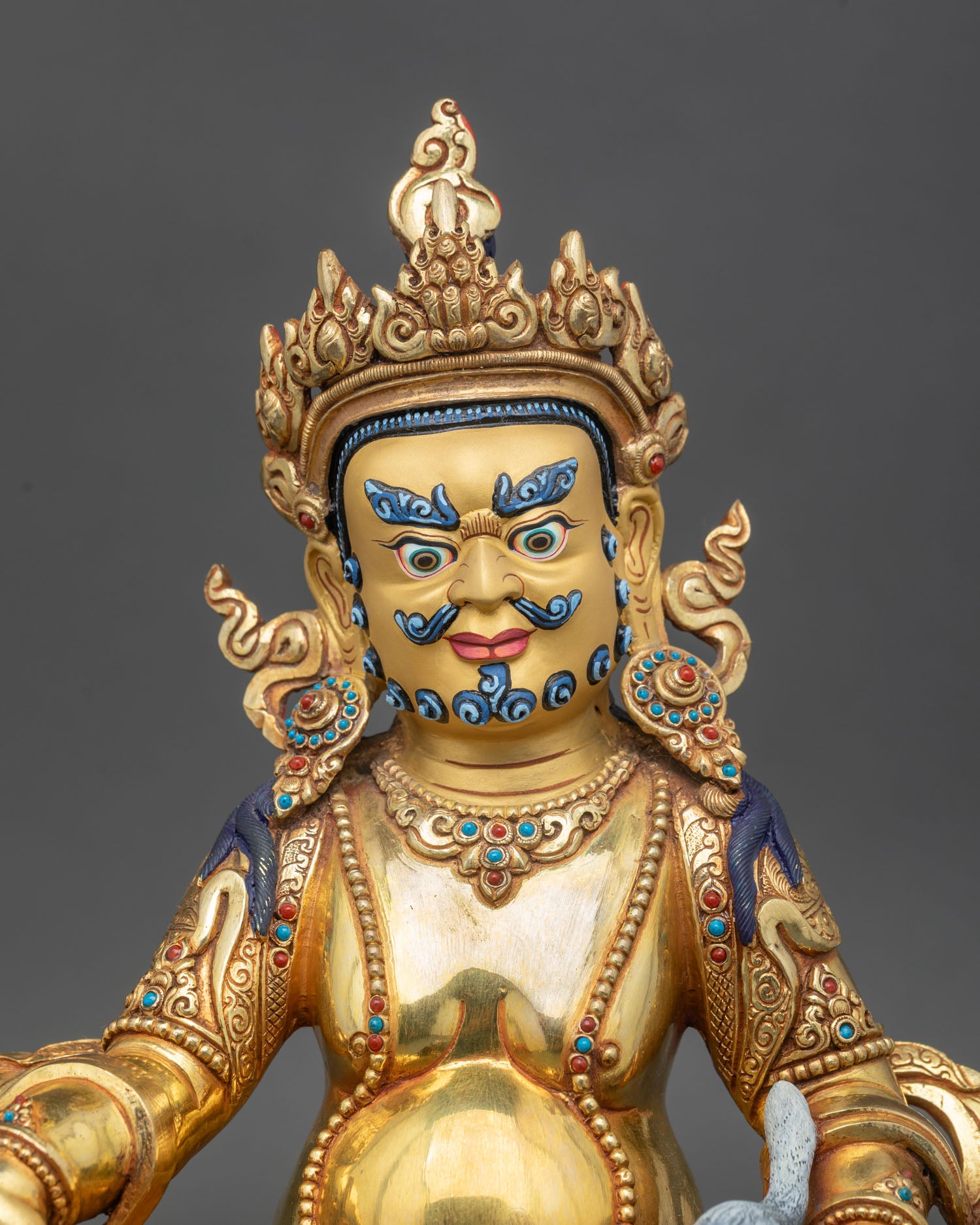 Close up Dzambhala face gold painted beard detail Newari handmade Nepal statue