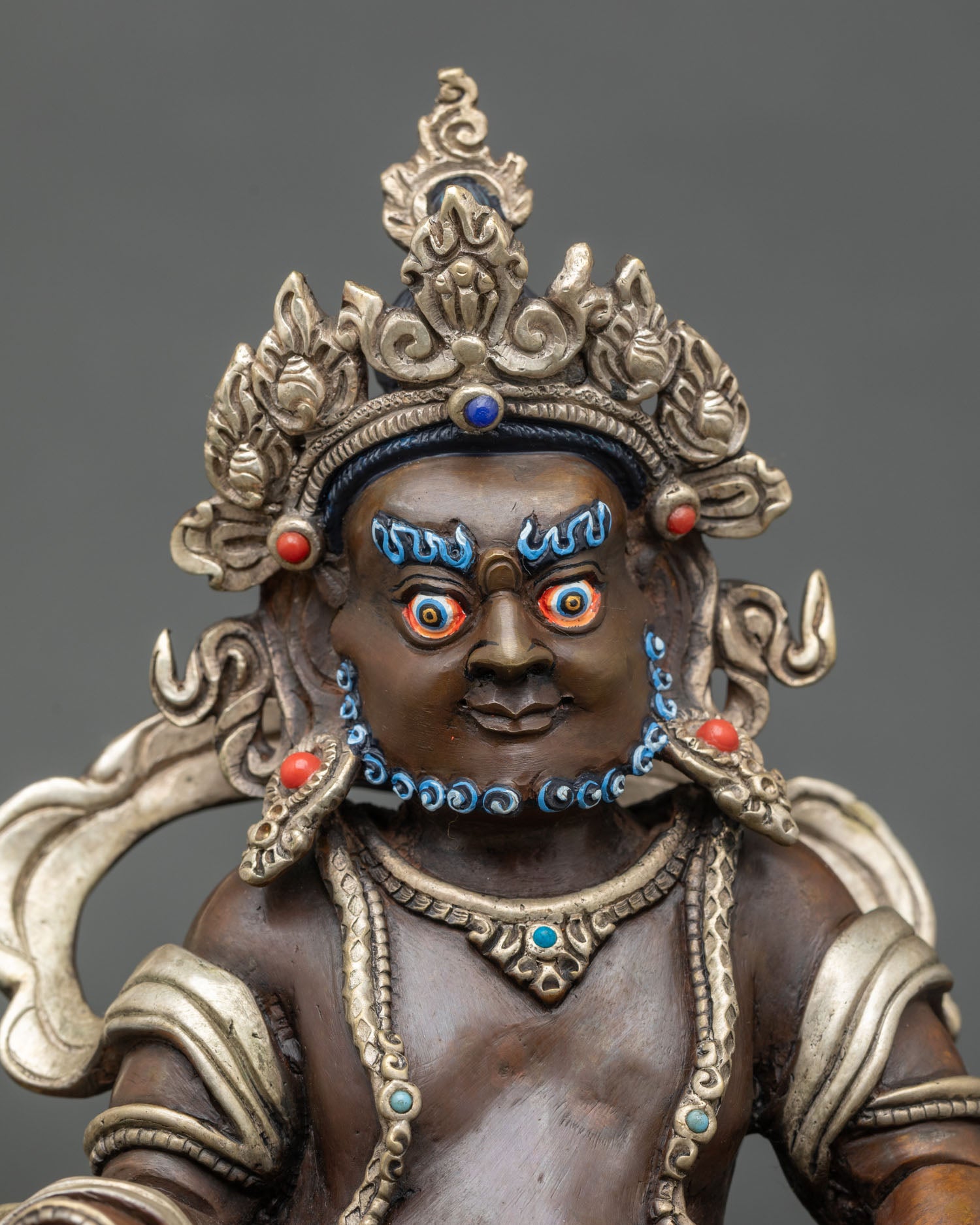 Close up Dzambhala statue ornate crown hand-painted colors and detailed ornaments