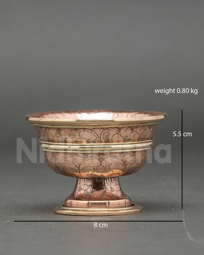 Close up engraved floral seven water offering bowl copper handcrafted Buddhist ritual