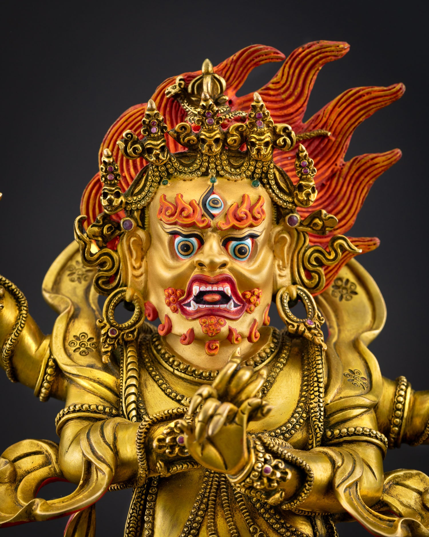 Close up Four Armed Vajrapani statue gold painted face third eye, enlightened protector Newari artisan craftsmanship Tibetan Buddhist sculpture