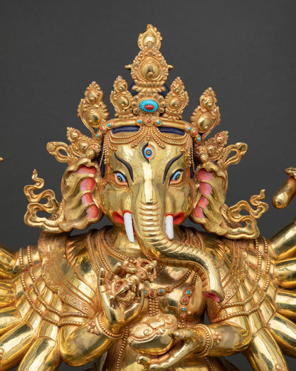 Close-up gold Ganesh statue face with ornate crown and third eye detail
