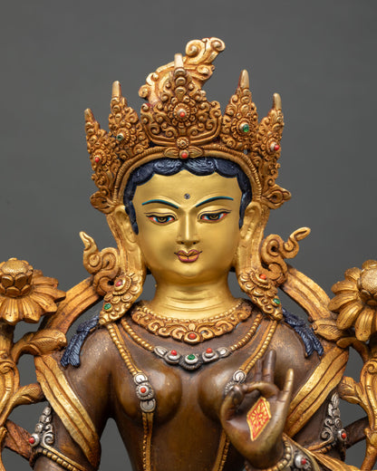 Close up Green Tara face gold painted detailing five jewel crown semi precious stones Himalayan artisan Buddhist deity sculpture detail