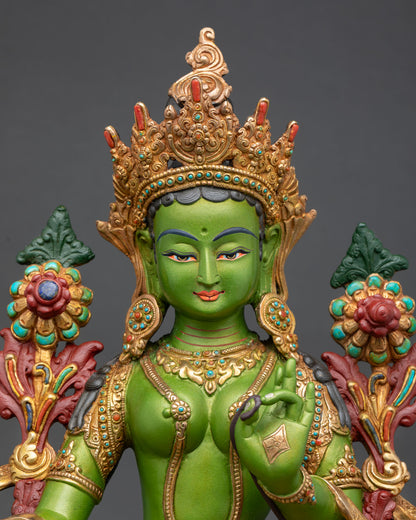 Close up Green Tara face with serene expression and intricate Himalayan Buddhist engraved metalwork