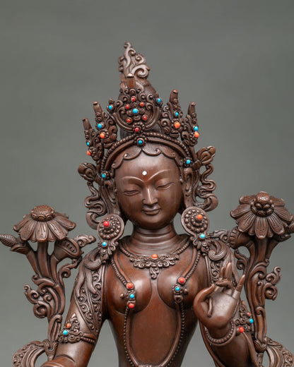 Close up Green Tara Statue gently closed eyes, five jewel crown and gemstone details