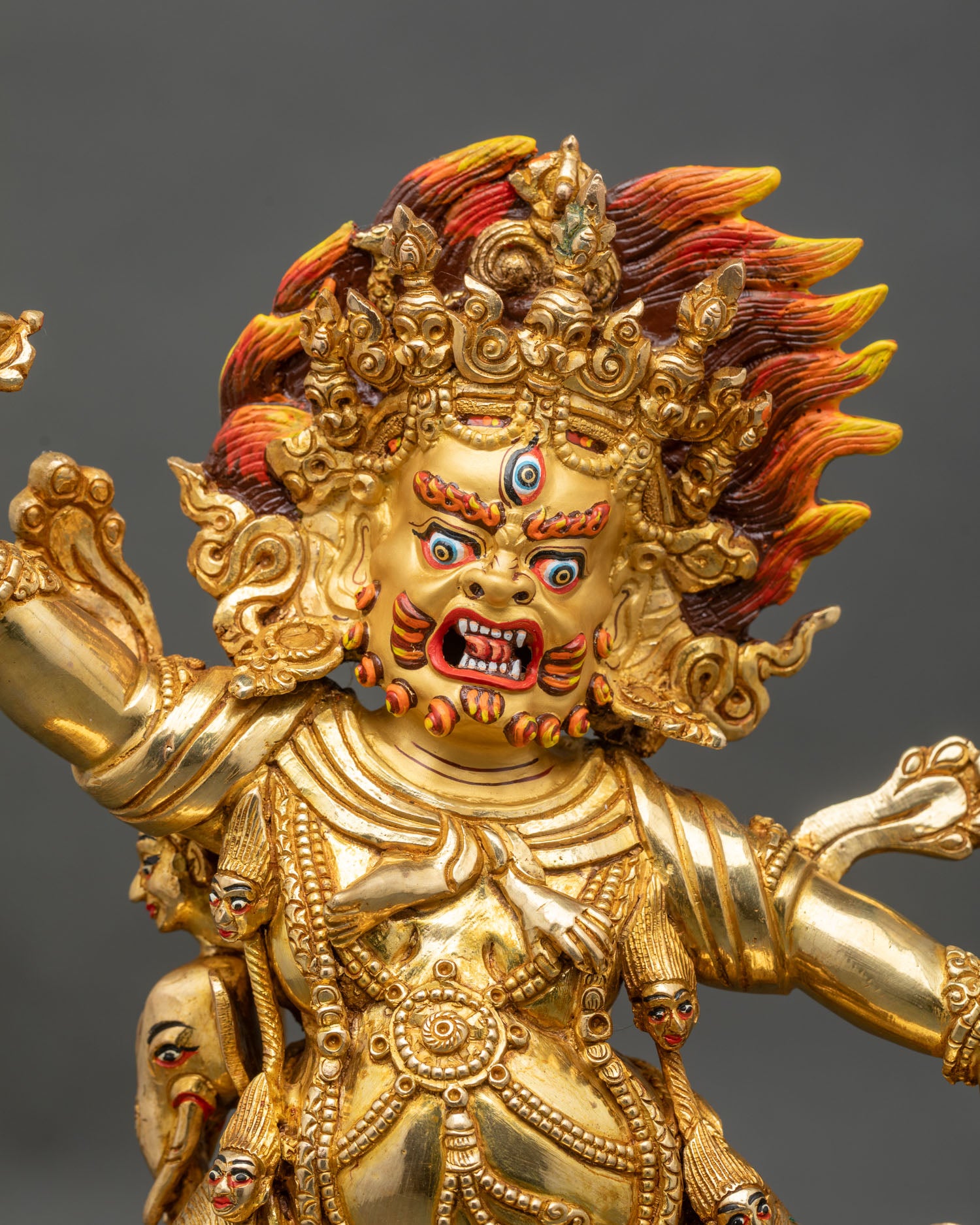 Close up Guru Dragpo statue wrathful face third eye gold gilded detail vajra scorpion symbolism