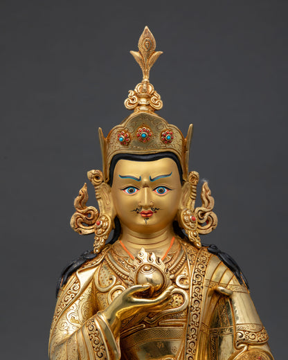 Close up view of Guru Norlha statue showing gold painted face semi precious stones and intricate engraved details