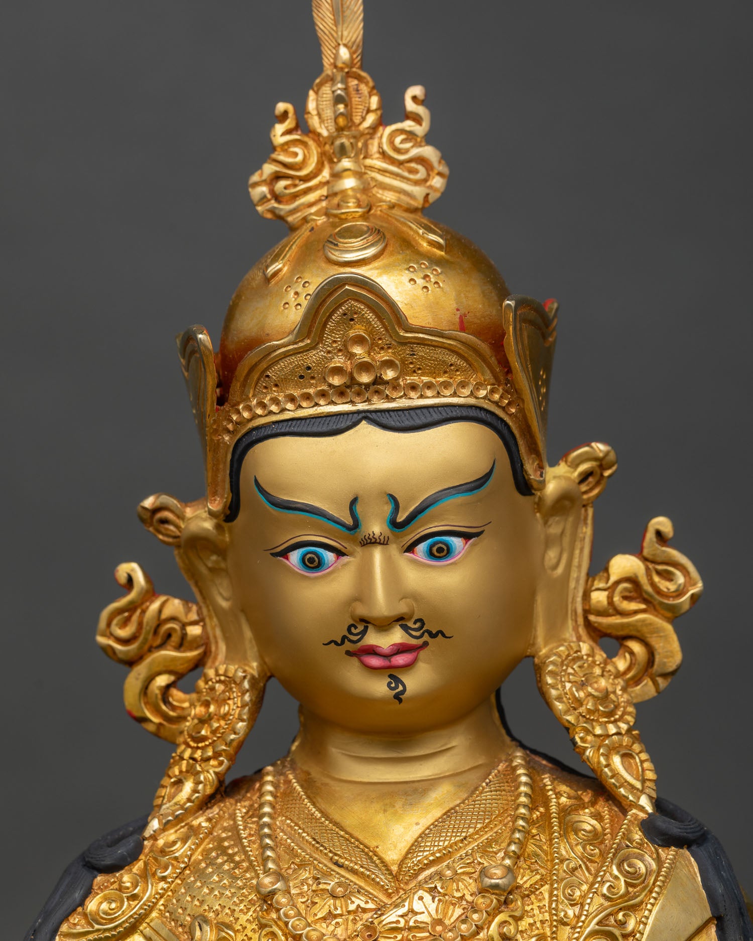 Close up Guru Rinpoche face 24K gold-painted handcrafted Newari artisan sacred deity