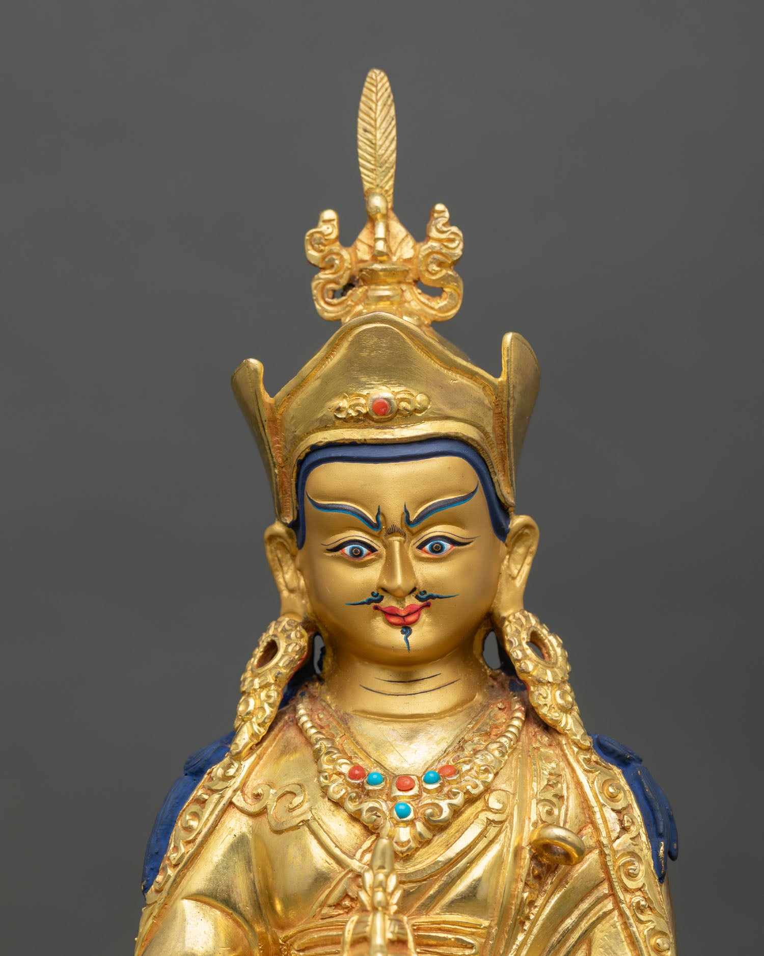 Close up Guru Rinpoche face gold painted expression vajra details Himalayan Newari craftsmanship Patan Buddhist sacred art statue