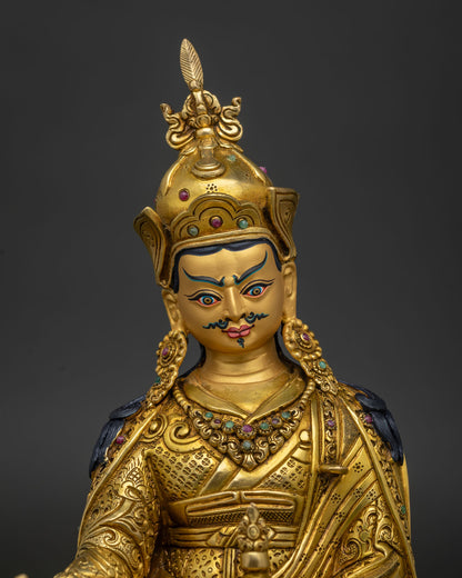 Close up Guru Rinpoche face with gold painted details and intricate Himalayan artistry