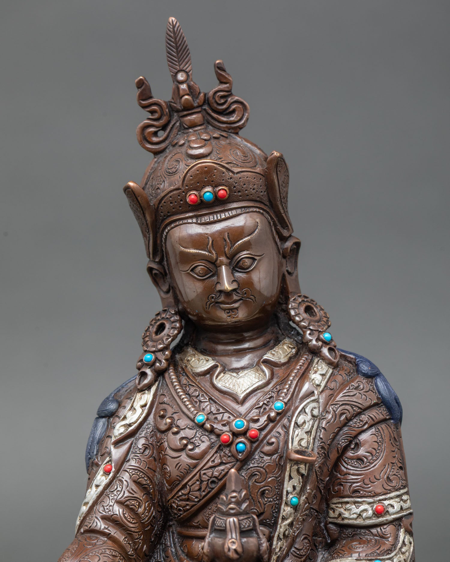 Close up Guru Rinpoche Padmasambhava statue showing detailed facial expression oxidized copper finish sacred Himalayan Buddhist art