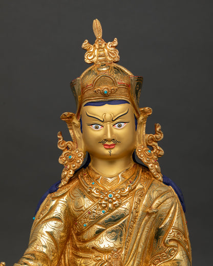 close up guru rinpoche padmasambhava statue showing gold painted face and sacred details
