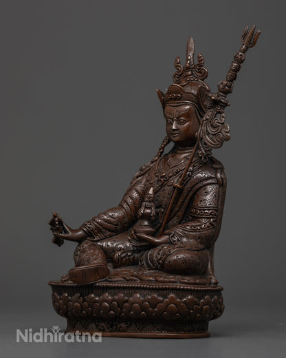 Close-up of Guru Rinpoche holding a vajra and skull cup with a sacred trident
