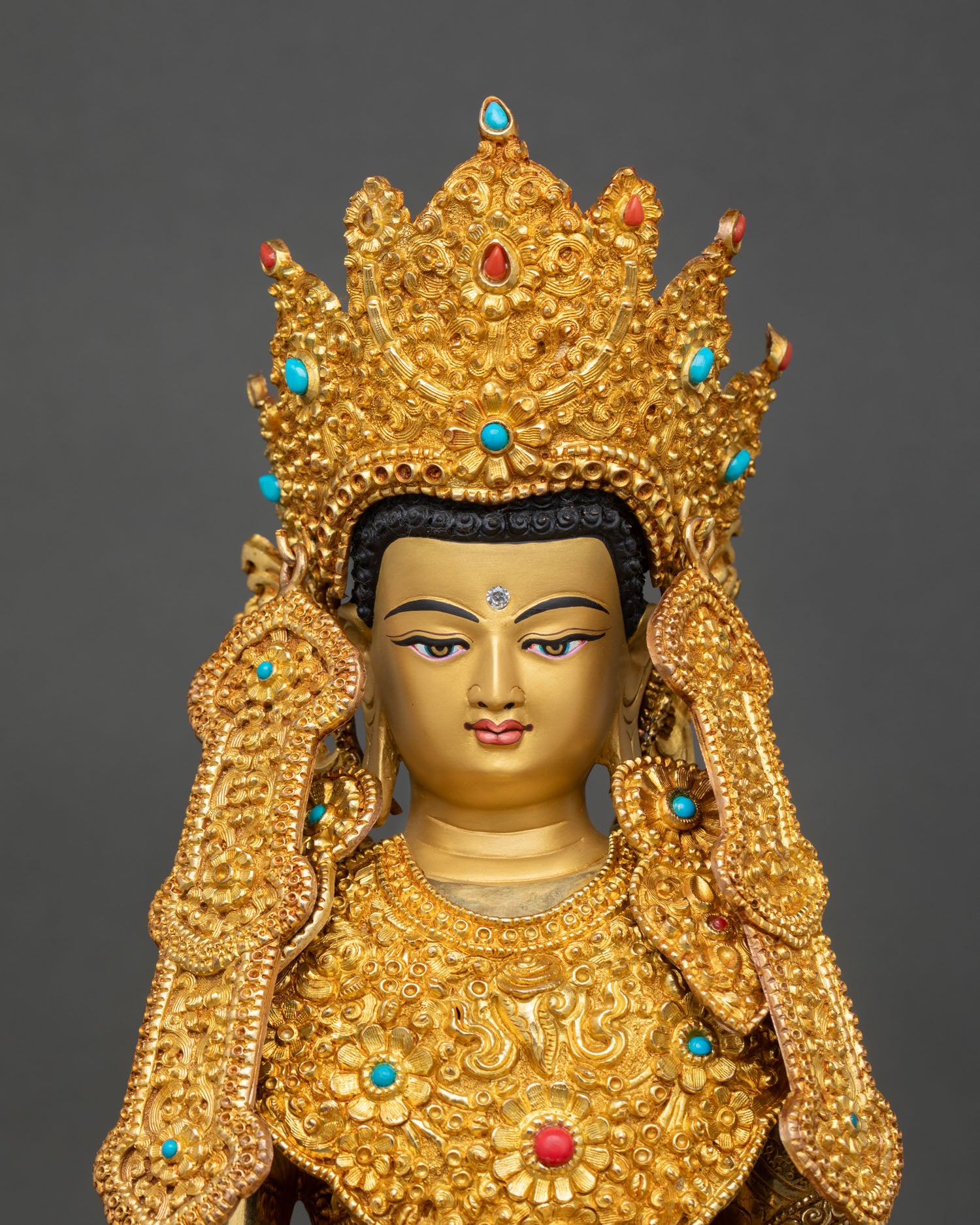Close up Jowo Rinpoche Buddha face with gold gilded finish semi precious stones ornate floral carvings and Himalayan Buddhist craftsmanship