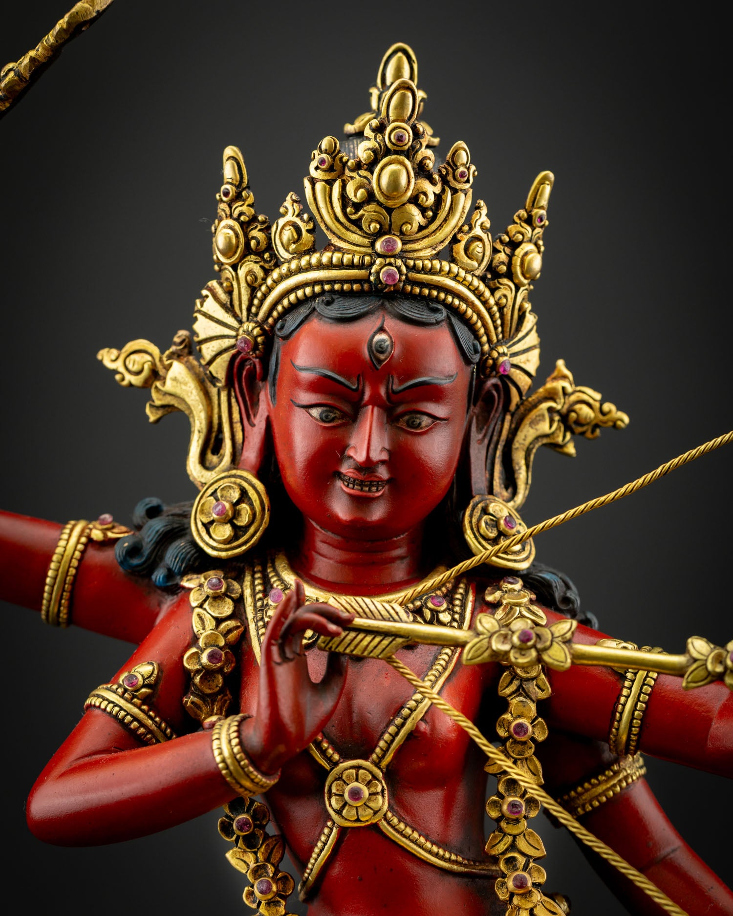 Close up Kurukulla four armed dakini statue crown of skulls flower tipped arrow bow hook and noose detailing Himalayan Vajrayana ritual art