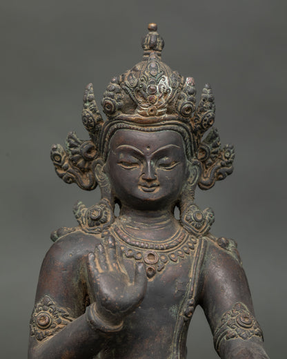 Close up Lokeshvara statue showing Abhaya Mudra and detailed antique copper finish.