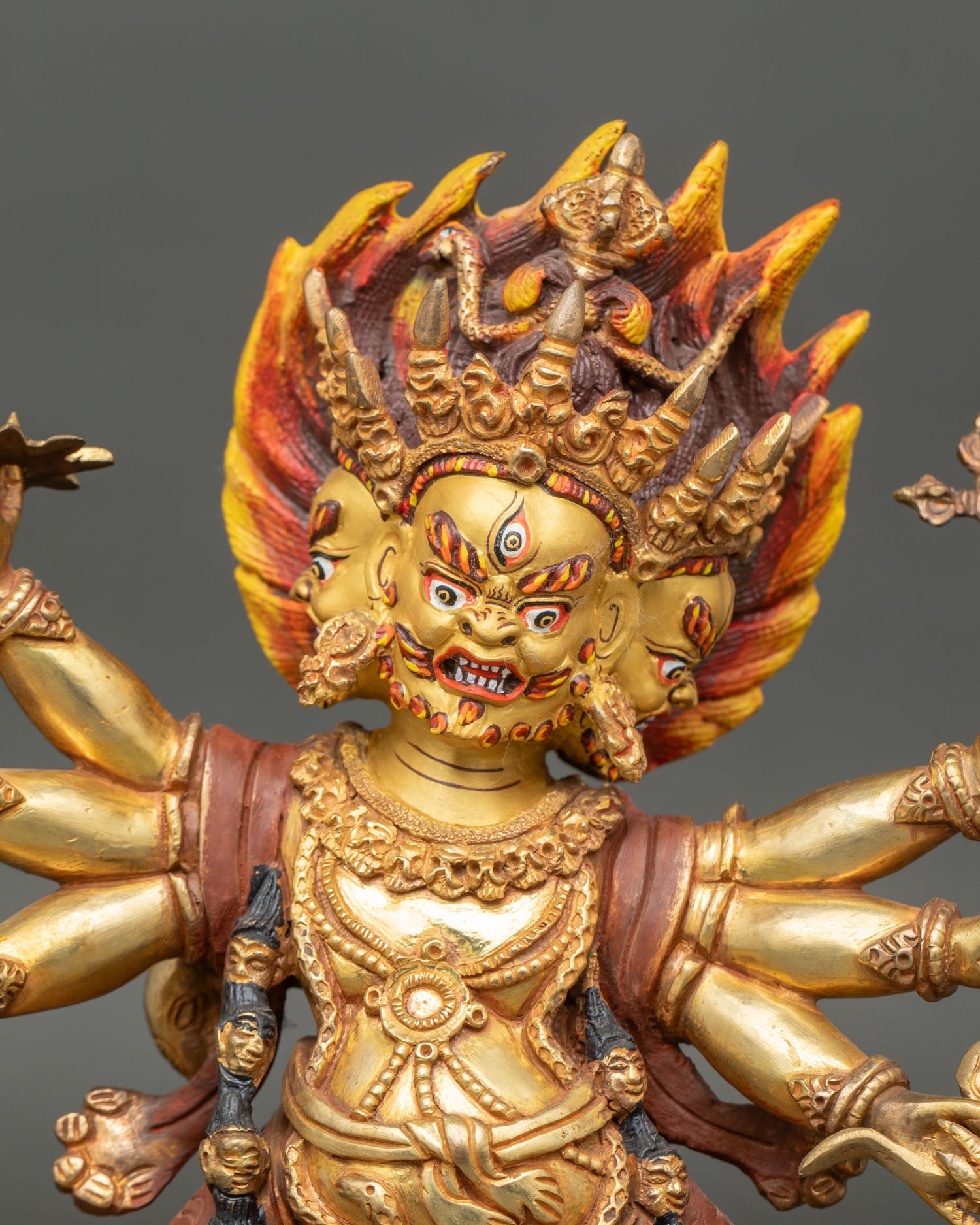 Close up Mahakala face detail three faced wrathful deity expression Himalayan Buddhist art Newari craftsmanship sacred protector statue gold painted finishing