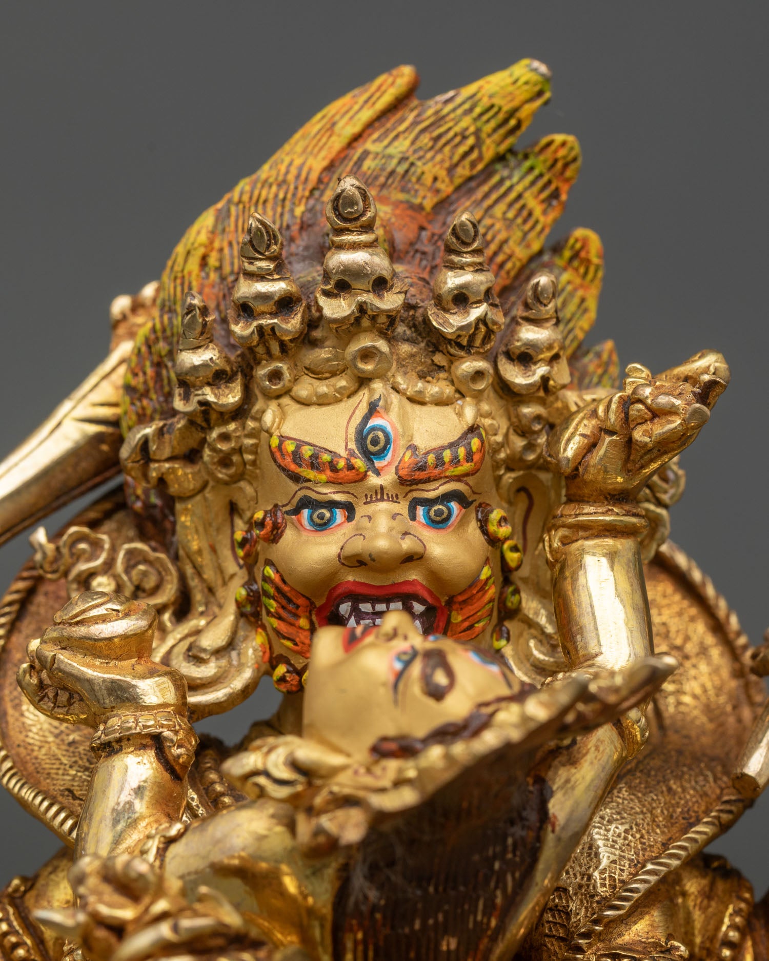 Close up Mahakala face gold painted expression wrathful protector detail Himalayan Newari craftsmanship Patan sacred Buddhist art statue