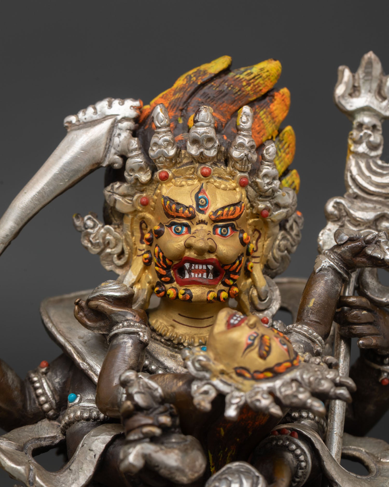 Close up Mahakala face gold painted fierce expression silver plated details Himalayan craftsmanship Patan Buddhist wrathful deity art