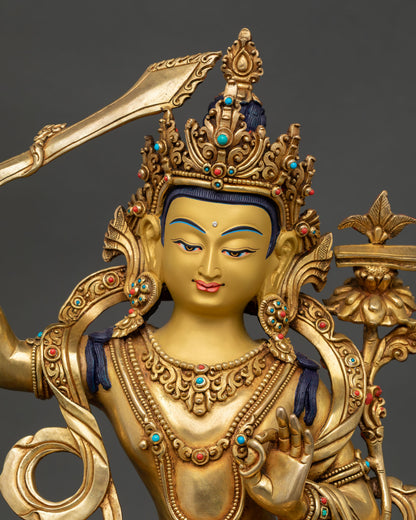 Close-up Manjushree Buddhist statue with flaming sword, Prajnaparamita scripture, and gold gilding