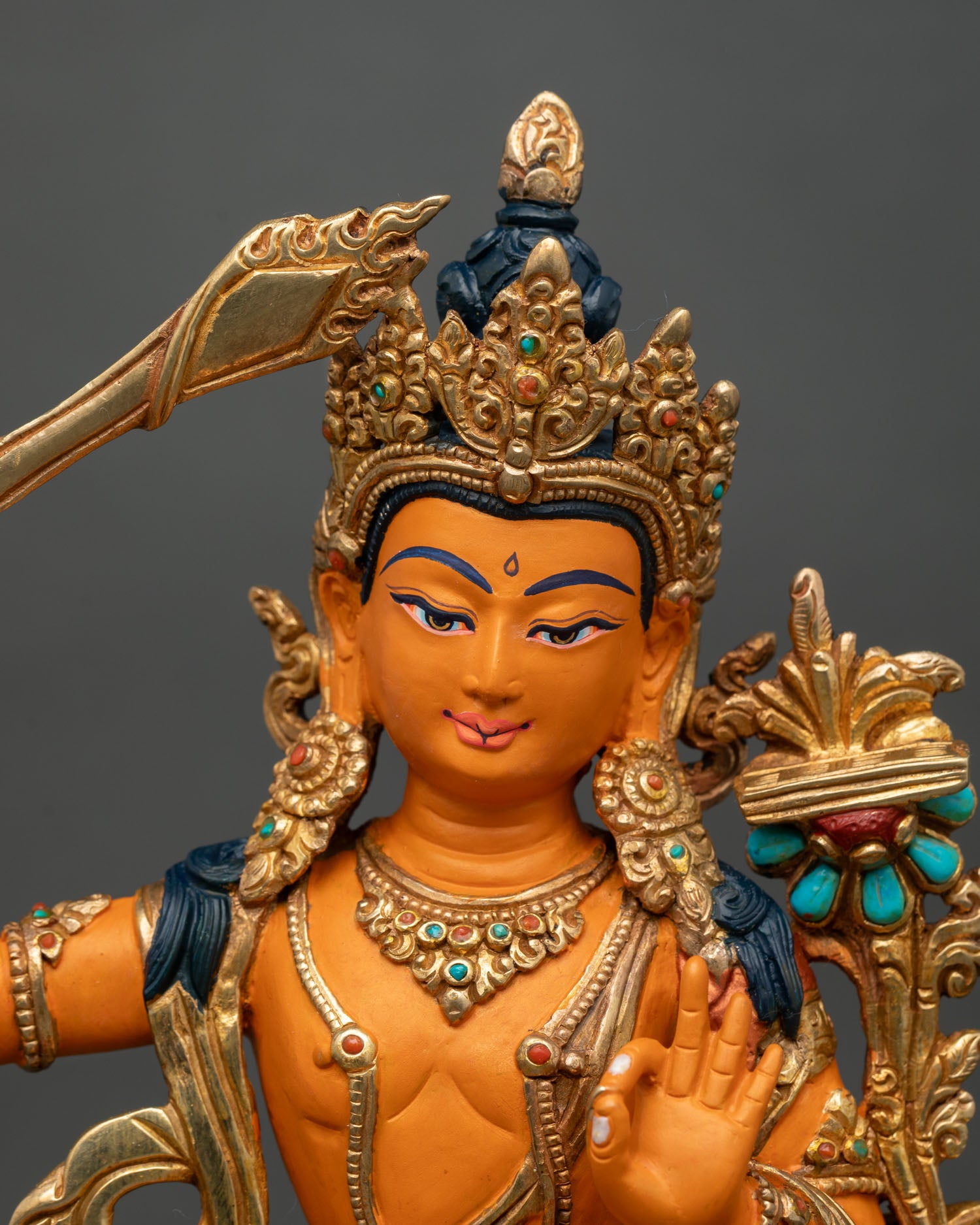 Close up Manjushri Bodhisattva face detailed acrylic paint semi precious stones sacred wisdom deity Buddhist art craftsmanship Nepal statue
