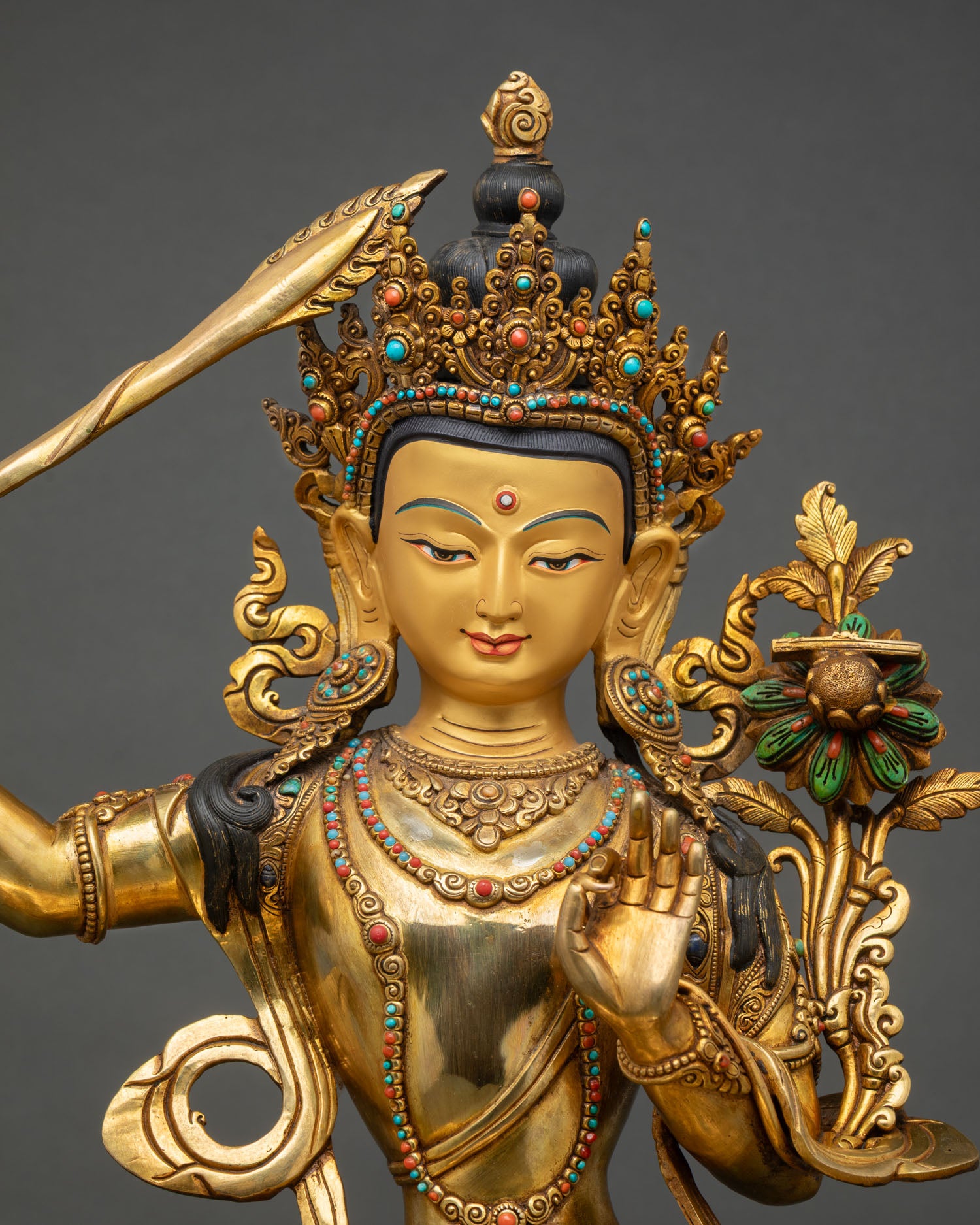 Close up Manjushri face detail gold painted serene expression ornate floral halo double lotus pedestal turquoise coral inlay Nepalese Buddhist sculpture