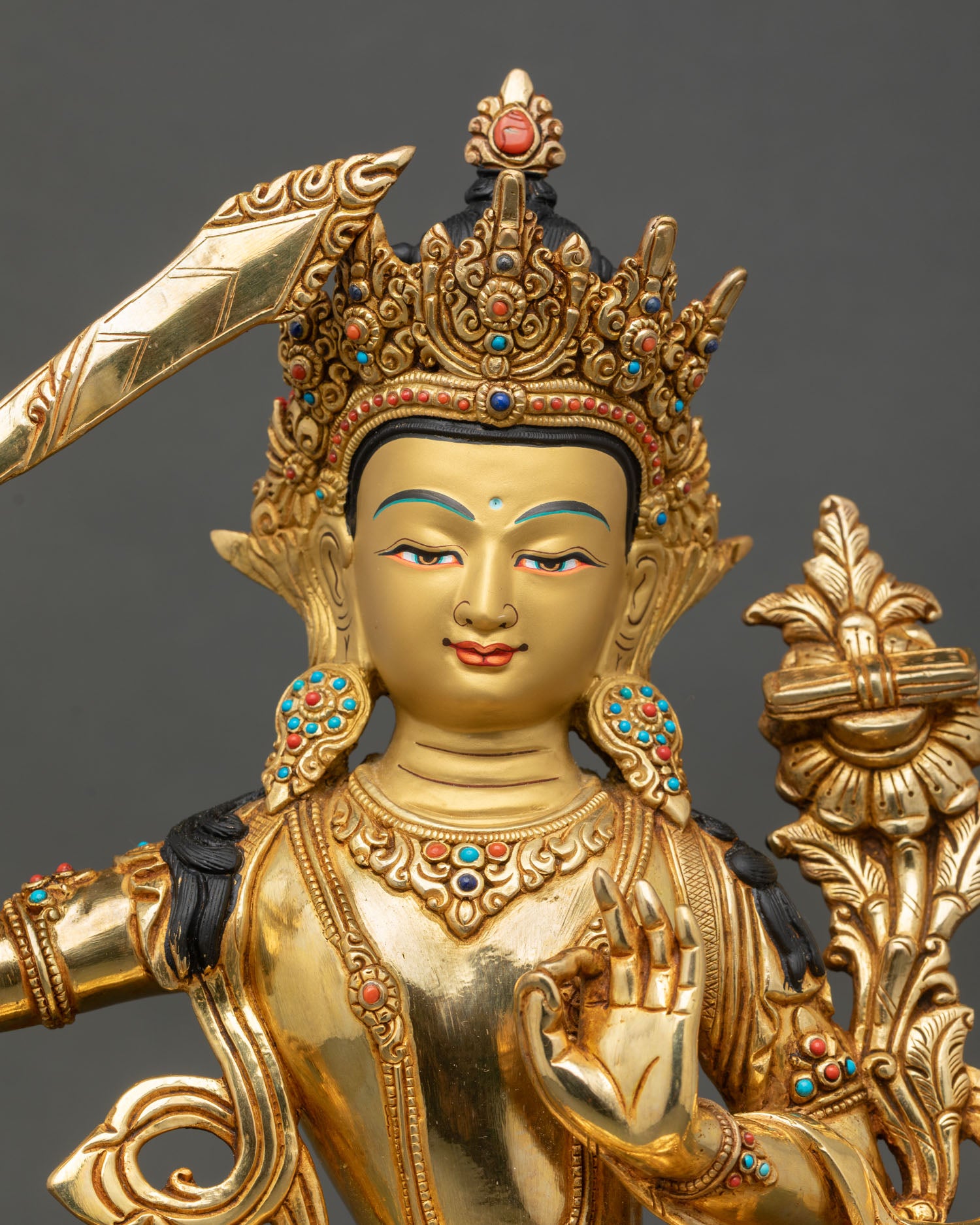 Close up Manjushri face detail serene expression gold painted features Newari artisan craftsmanship Patan Nepal sacred Buddhist art