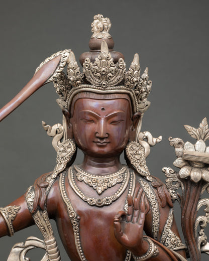 Close up Manjushri face detail showing serene expression and sacred craftsmanship lost wax copper sculpture from Nepal