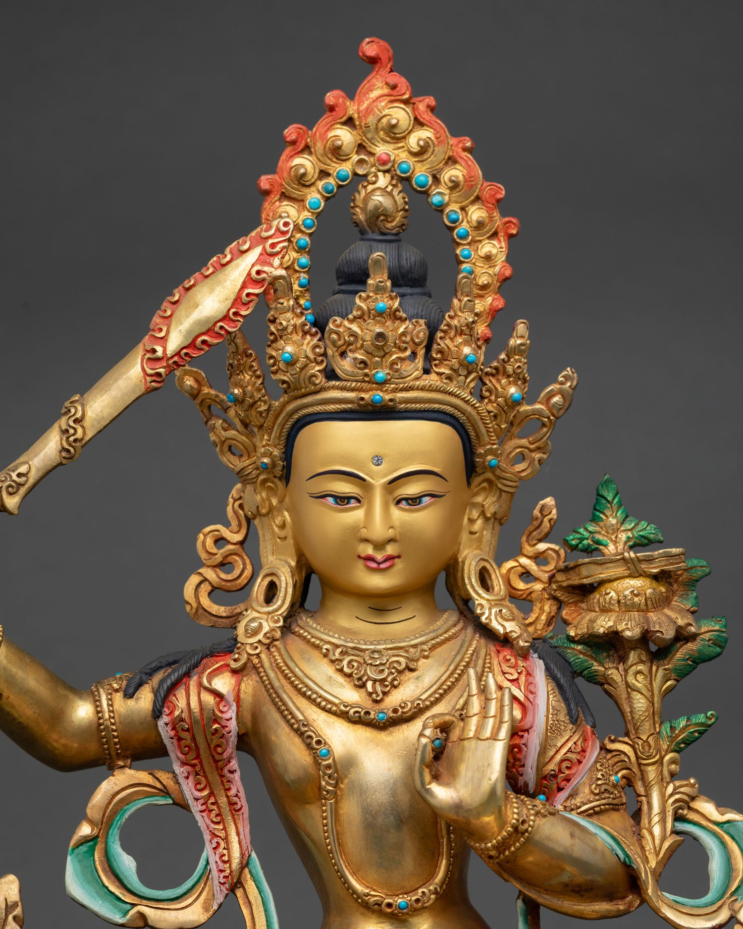 Close up Manjushri face gold painted details semi precious stones Newari artisan craftsmanship sacred Buddhist wisdom deity sculpture radiant expression