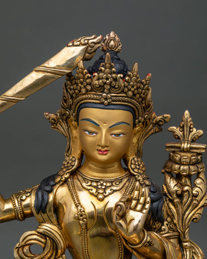 Close up manjushri statue with 24k gold painted face and ornate five jewel crown.
