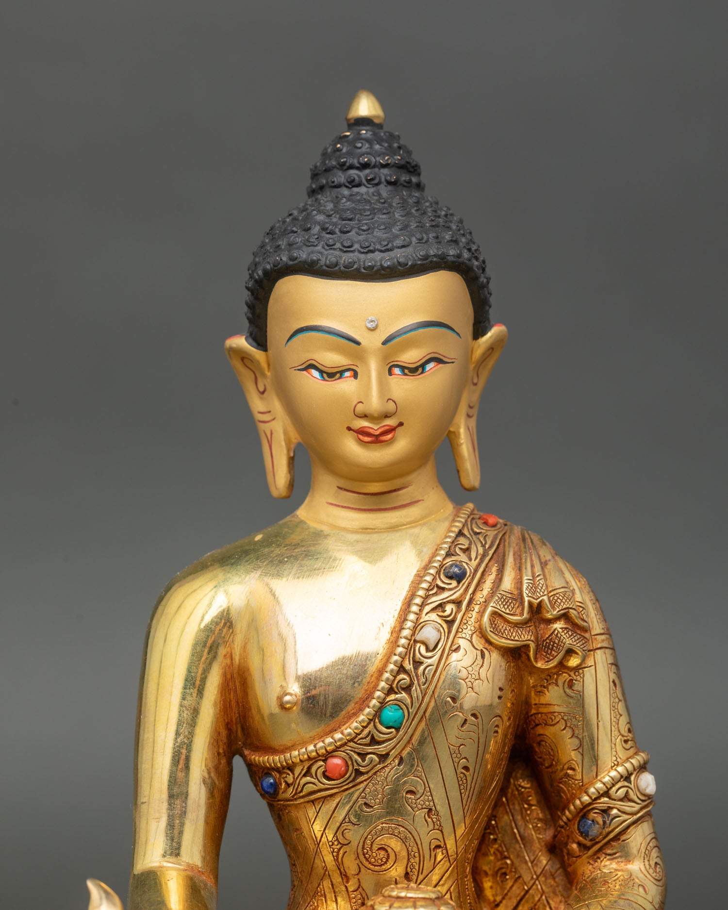Close up Medicine Buddha serene gold painted face semi-precious stones inlay