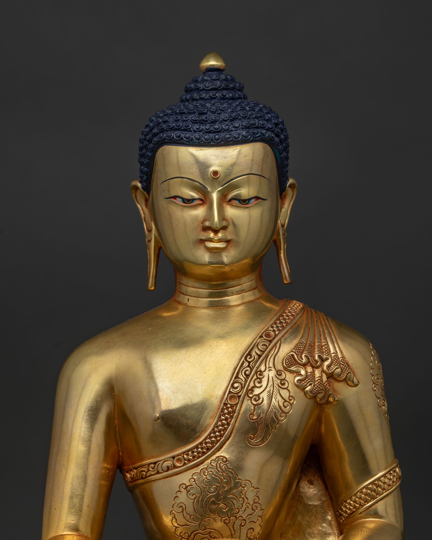 Close-up of 24K gold fire-gilded Shakyamuni Buddha statue showing fine Newari copper craft details.
