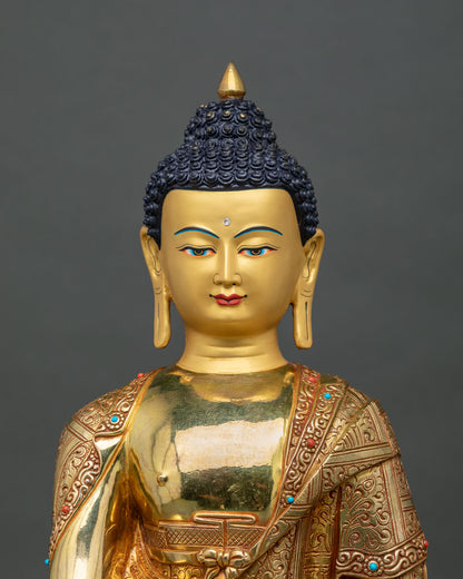 Close up of 24K gold Shakyamuni Buddha statue showing earth-touching mudra and begging bowl.