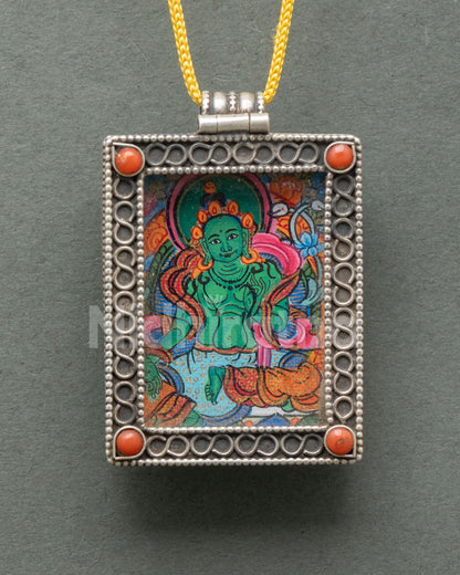 Close-up of a handcrafted Green Tara locket showcasing delicate silver filigree semi-precious coral stones and traditional Newari craftsmanship from Nepal.