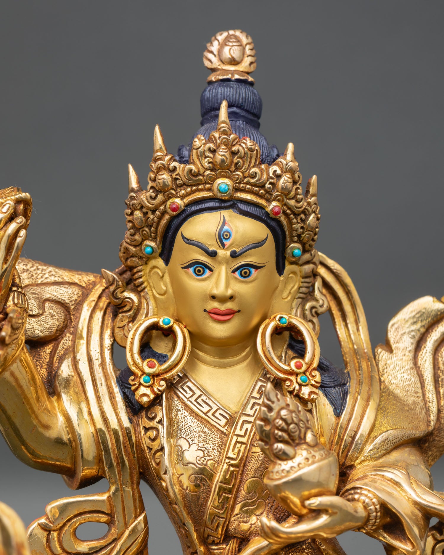 close-up of achi chokyi drolma statue with turquoise coral inlay and gold finish
