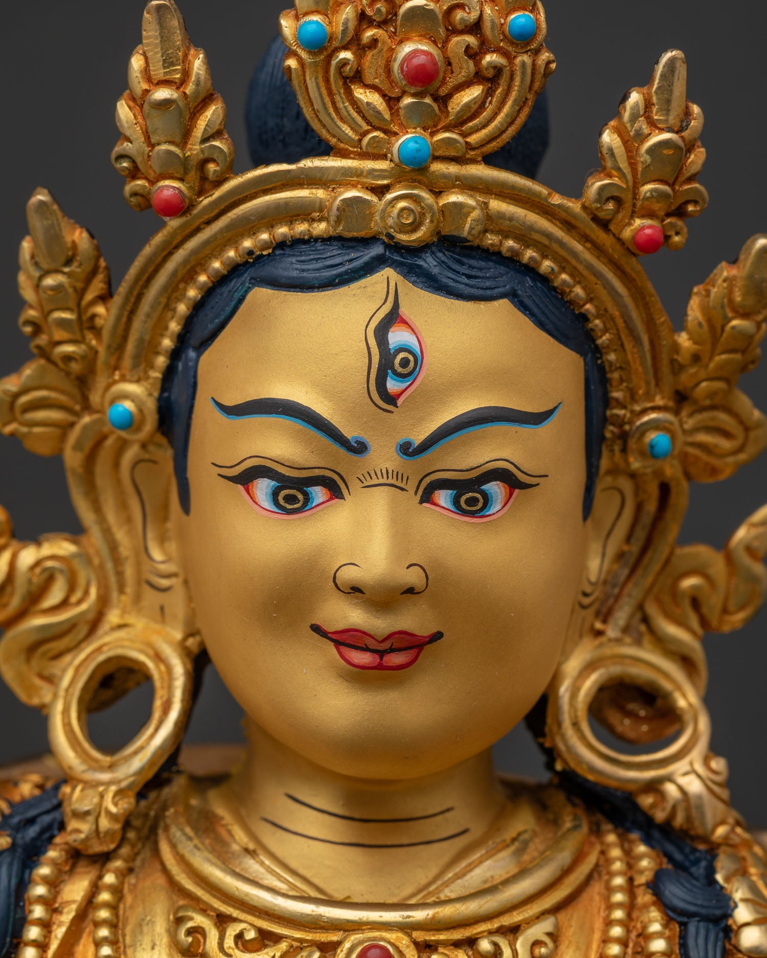 Close-up of Achi Chokyi Drolma's serene, gold-gilded face and crown