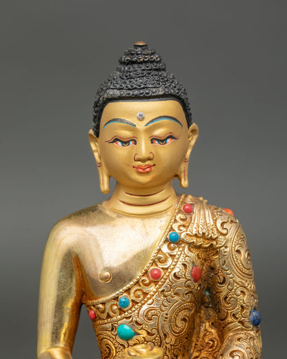 Close up of Amitabha Buddha’s gold-painted face, featuring vajra, turquoise, and coral stones.