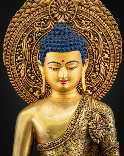 Close‑up of Amitabha Buddha statue showing gold fire‑gilded robe with floral motifs and gemstone inlays